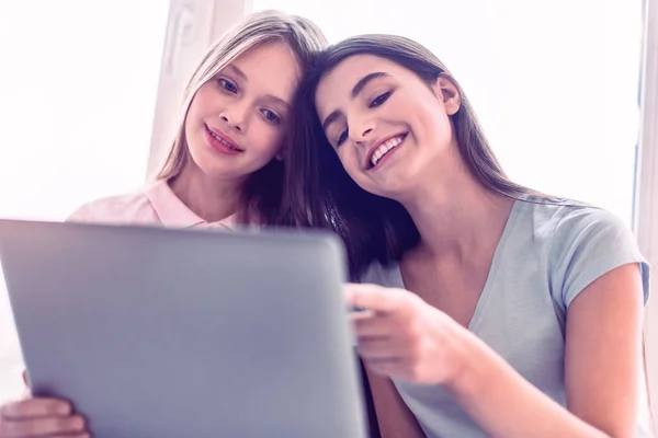 Nice teenagers sitting with laptop near the window — Stock Fotó