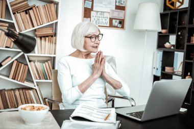 Amazing retired female sitting in front of computer