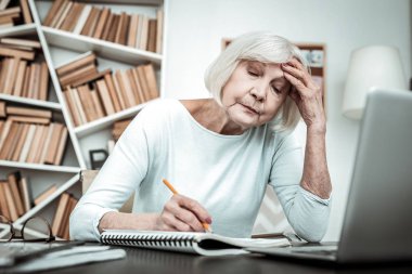 Olgun öğretmen test kağıt Check-up yapıyor yorgun