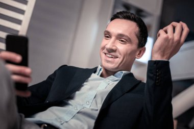 Smartphone ekrana bakarak mutlu neşeli adam