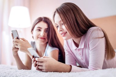 İki kız onların telefon ile mesajlaşma sevindim