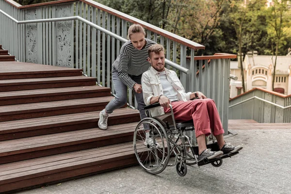 Ung blond tjej att hjälpa hennes handikappade partner — Stockfoto