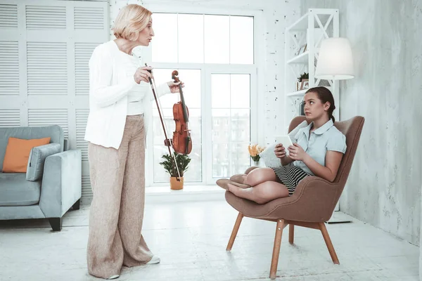 Mujer rubia sin ánimo haciendo que su nieta toque el violín —  Fotos de Stock