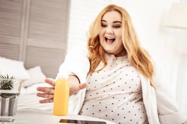 Riéndose de pelo largo jengibre mujer siendo feliz con la botella de jugo — Foto de Stock