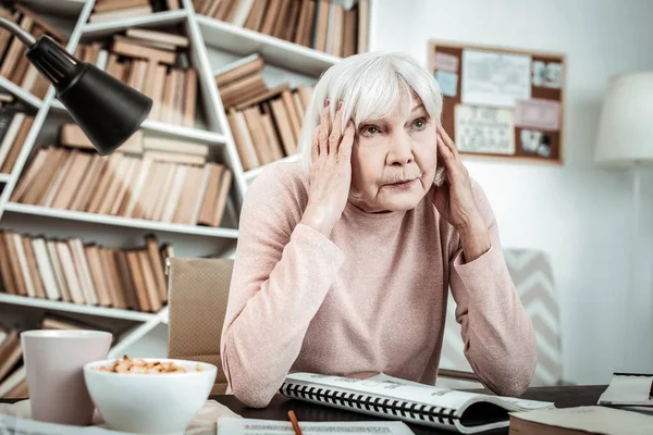 Frustrated blonde mature woman trying to concentrate — Stock Photo, Image