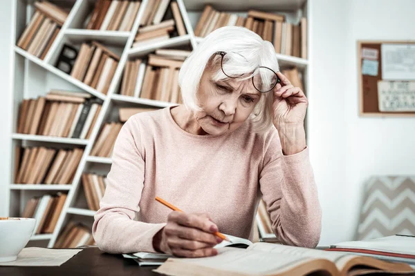 Concentrated mature woman completing her home task — Stock Photo, Image