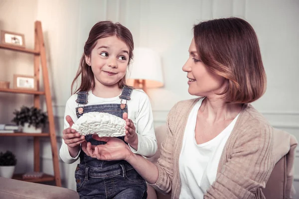 Cute delighted girl holding a brain model — Stock Photo, Image