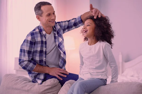 Feliz hombre positivo tocando el pelo de sus hijas —  Fotos de Stock