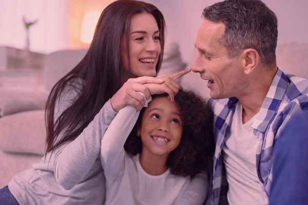 Vrolijke positieve meisje haar vaders neus met de vinger aanraken — Stockfoto