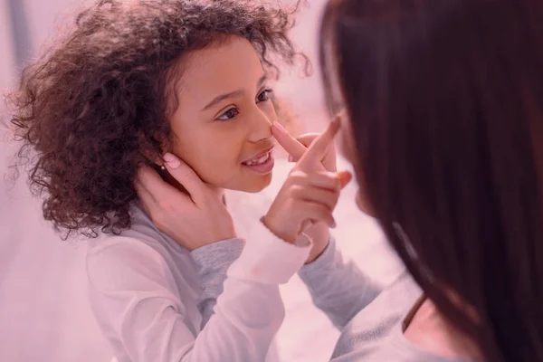 Linda niña pequeña tocando la nariz de sus madres —  Fotos de Stock