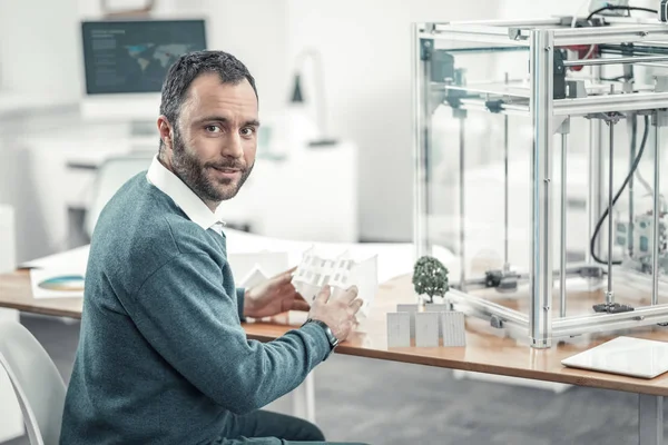 Positive bearded man sitting at the table