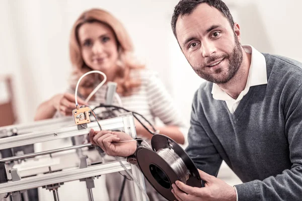 Bonito homem barbudo que trabalha com equipamento de escritório — Fotografia de Stock