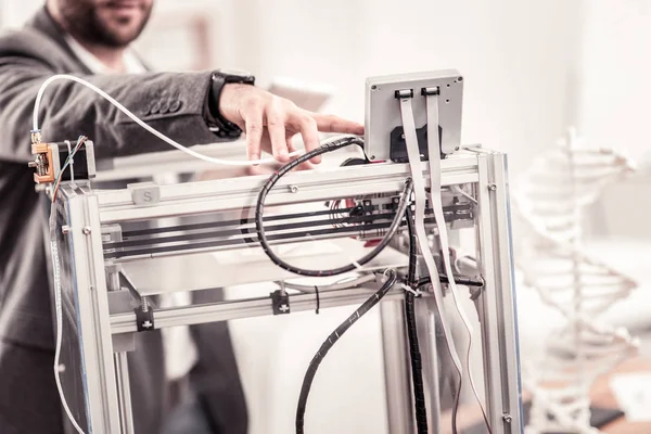 Primo piano della mano dell'uomo che regola la stampante 3D professionale — Foto Stock