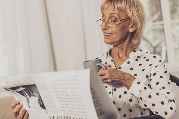 Расслабленный пенсионер с удовольствием читает газеты — стоковое фото