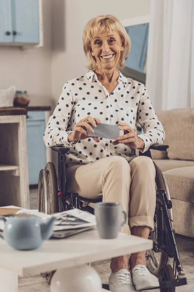 Positive delighted инвалида женщина находится дома — стоковое фото