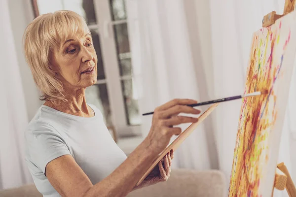 Attenta donna anziana godendo il suo hobby — Foto Stock