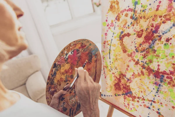 Focused photo on serious woman that looking at easel — Φωτογραφία Αρχείου