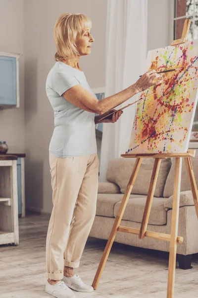 Концентрована жінка малює абстракцію — стокове фото