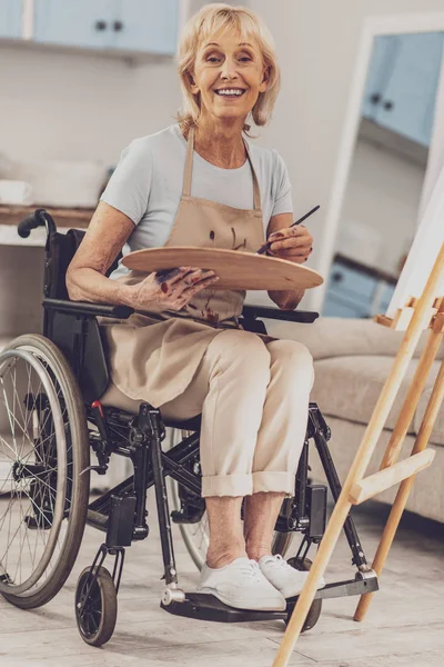 Persona femenina bastante mayor sentada en silla de ruedas — Foto de Stock