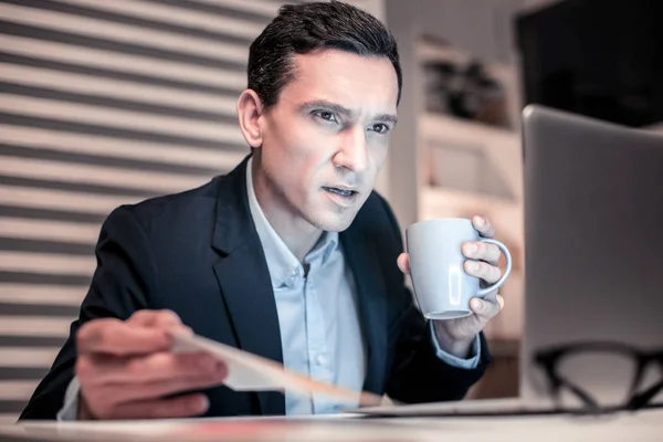 Un hombre serio y agradable mirando la pantalla de la computadora — Foto de Stock