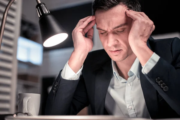 Smart netter müder Mann, der seine Schläfen berührt — Stockfoto