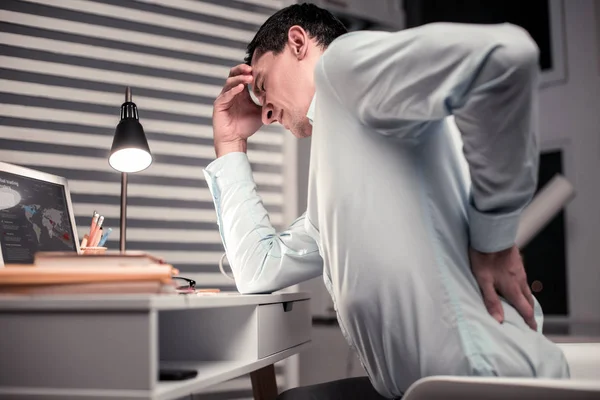 Безвеселий втомлений чоловік відчуває біль у спині — стокове фото