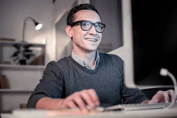 Веселий позитивний чоловік дивиться на екран комп'ютера — стокове фото