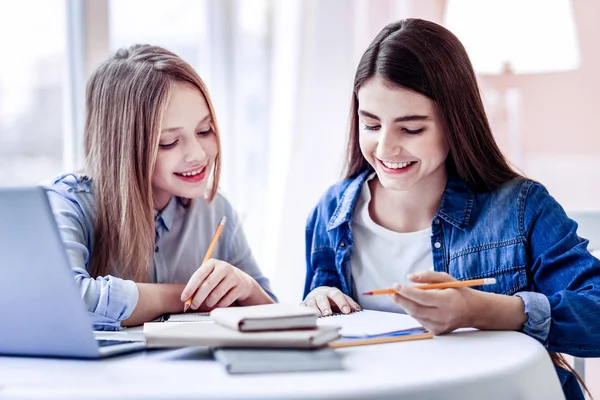 Happy merry two girls solving difficult puzzle — Stock Photo, Image