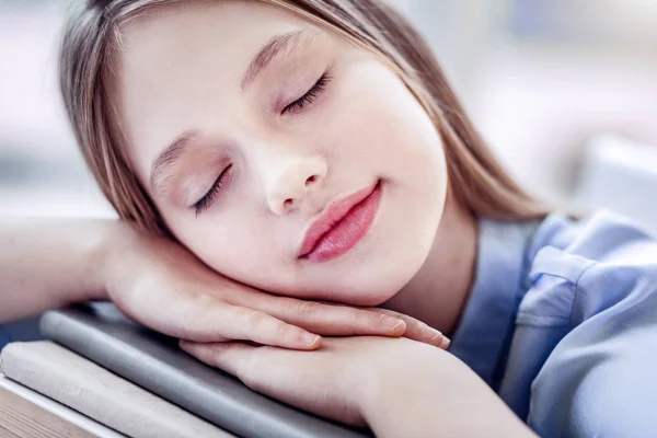 Beautiful appealing girl dreaming on many books — Stockfoto