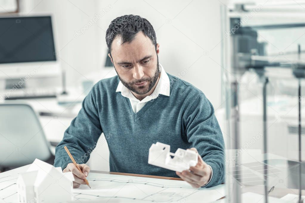 Smart nice adult man drawing a detail