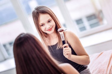 Charming two girls finishing makeup before party clipart