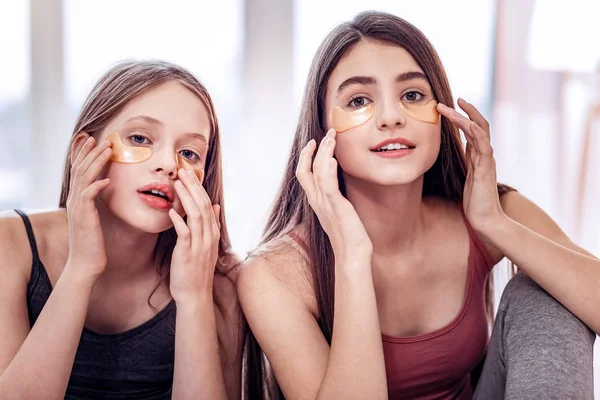 Appealing two girls trying eye patches together — Stock Photo, Image