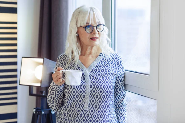 Agradável mulher agradável de pé com uma xícara de café — Fotografia de Stock