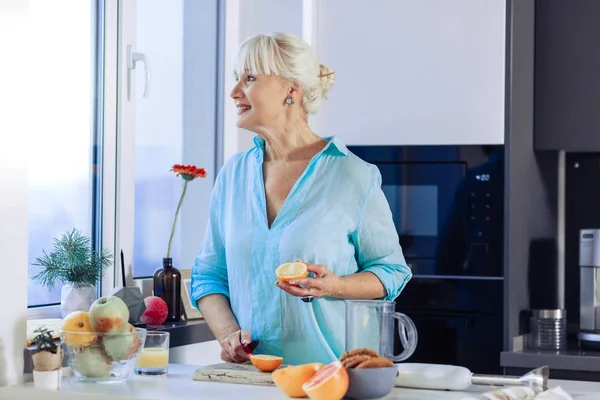 Mulher alegre positivo segurando uma metade laranja — Fotografia de Stock