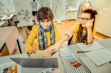 Neşeli birlikte. İyi görünümlü şık erkek ve kız atelier içinde birlikte okurken neşeli hissediyorum