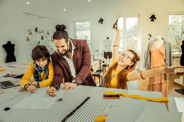 Rothaariges Mädchen, das sich bei der Arbeit mit Vater erstaunlich heiter fühlt — Stockfoto