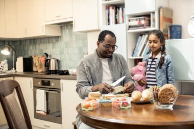 Sevimli kızı pembe oyuncak izlerken babamla yemek kahvaltı
