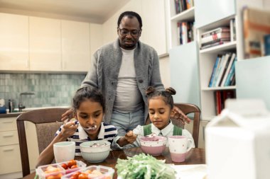 Sevgi dolu babası onun güzel İkizler için kahvaltı veren bakım