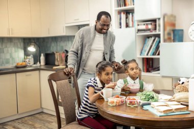 Gülümseyen baba. Mutlu gülümseyen Afrikalı-Amerikalı babası onun ikiz Kahvaltı izlerken