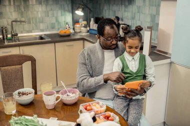 Kahvaltı yedikten sonra babası dizlerinin üstüne oturan kızı