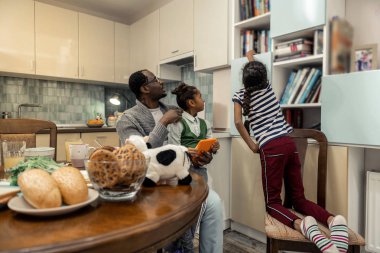 Kızları şefkatli babalarıyla kitap okurken kitap çekiyorlar