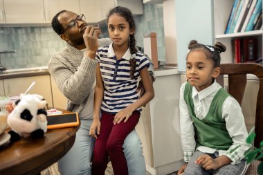 Onun büyük kızı dizlerinin üzerinde oturan için saç modeli yapma baba