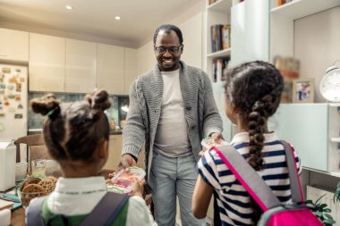 İki esmer kızı okula öğle yemeği kutuları alarak