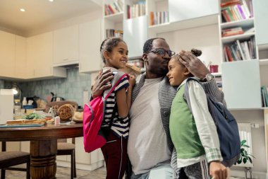 Gülümseyen sevgi dolu iki kızı onu sarılma babaları geliyor