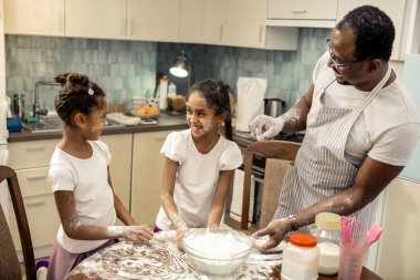 Gözlük ve kızları ile eğleniyor çizgili önlük giyen baba