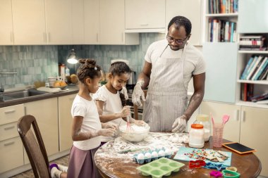 Kek pişirme kızları yardımcı çizgili önlük giyen baba