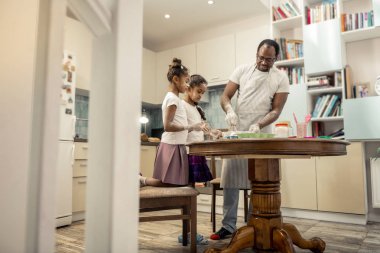 Bearded father feeling amazing while cooking with his girls
