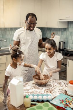 İki sevimli kız babası ile hafta sonu pişirme sırasında oyun oynuyor