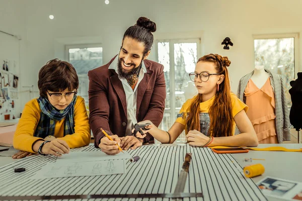 Talentoso diseñador de moda dibujar bocetos cerca de sus hijos —  Fotos de Stock