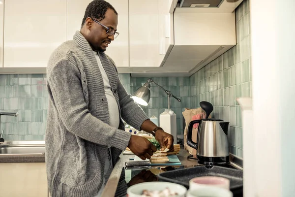 Cuidar do marido amoroso fazendo sanduíches matinais na cozinha — Fotografia de Stock